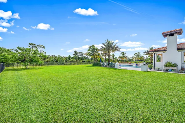 a view of swimming pool with outdoor seating and palm trees