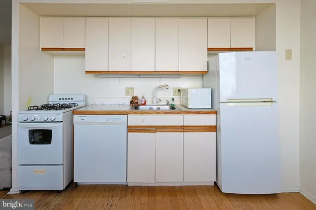 a kitchen with appliances a sink and cabinets