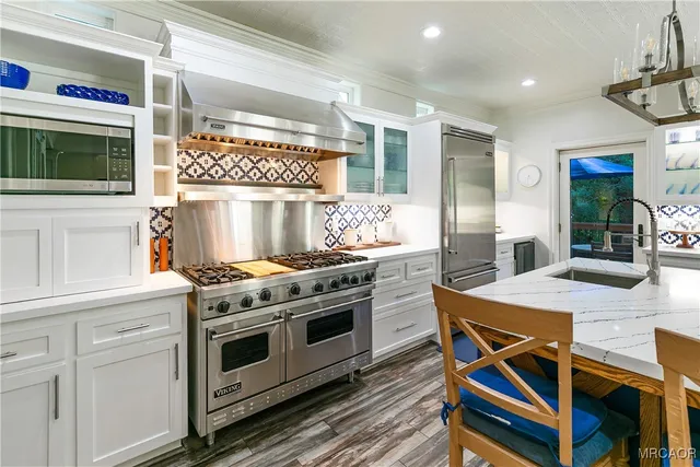 a kitchen with a stove cabinets and wooden floor