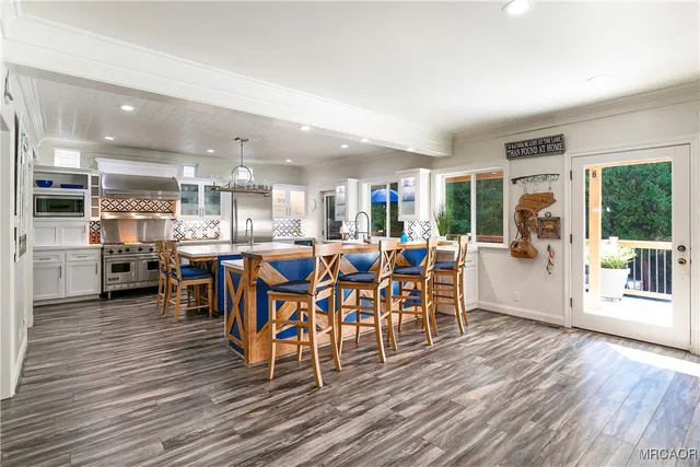 a dining room with furniture a kitchen view and wooden floor
