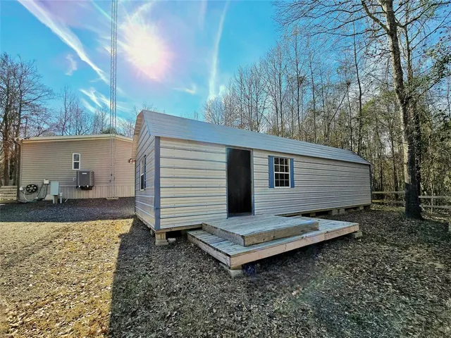 a view of a small house with backyard