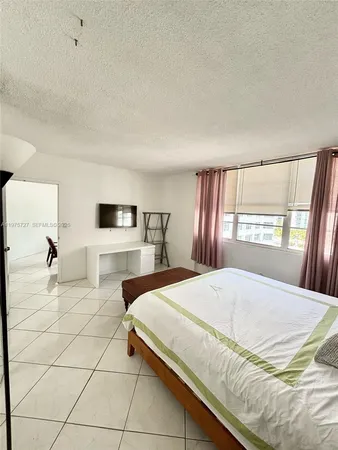 a bedroom with a large bed and a window