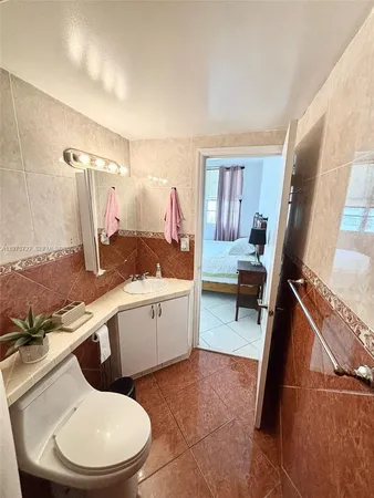 a bathroom with a granite countertop toilet sink and mirror
