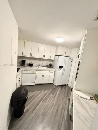 a view of kitchen with white cabinets and white appliances