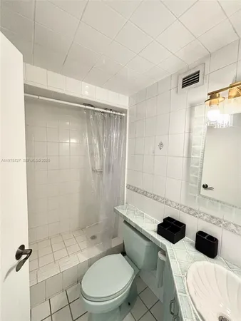 a bathroom with a toilet a sink and shower