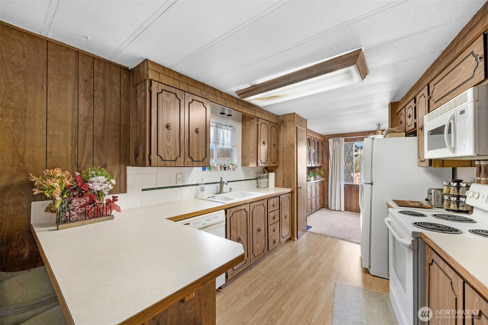 2200 196th Street Southeast, Unit 76 Bothell, WA 98012 - Photo 6 of 27 a large white kitchen with wooden floor and a sink