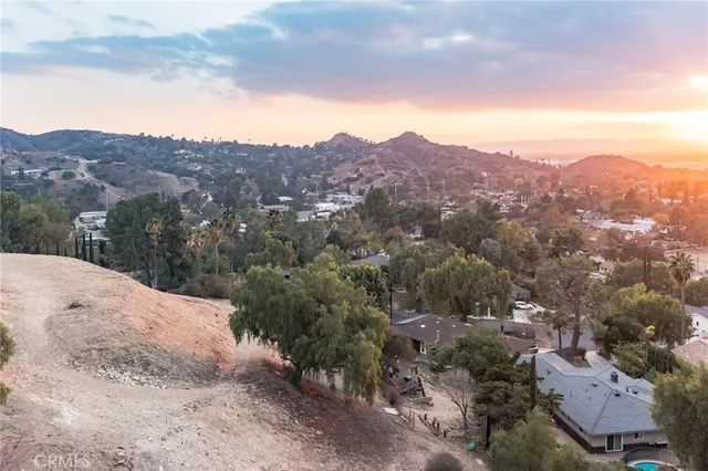 an aerial view of house with yard and mountain view in back