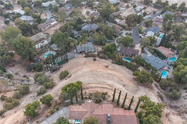 a view of a dry yard with wooden fence