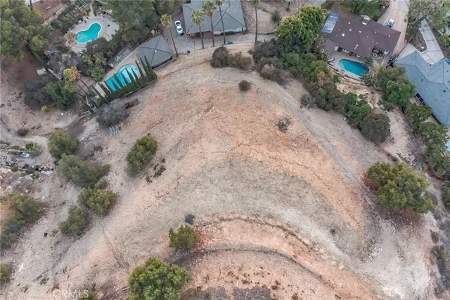 a view of a dry yard with trees