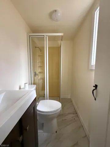 a bathroom with a sink a toilet a mirror and shower