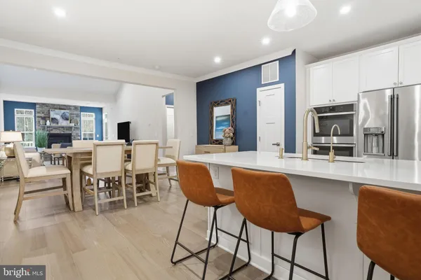 a dining hall with stainless steel appliances kitchen island granite countertop a dining table and chairs