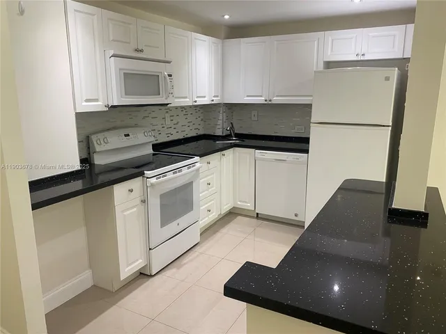 a kitchen with a refrigerator sink and cabinets
