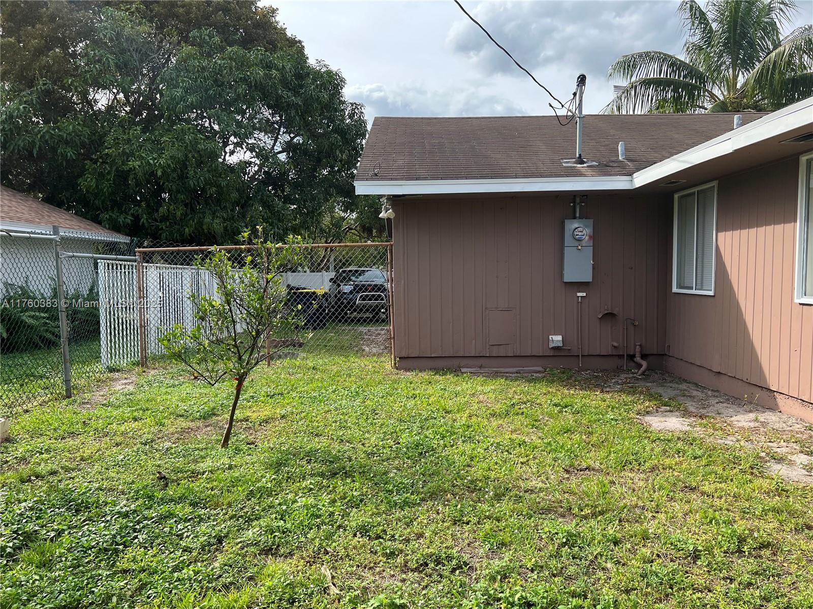 Dania Beach Dania Beach, FL 33312 - Photo 17 of 20 a backyard of a house with plants and a large tree