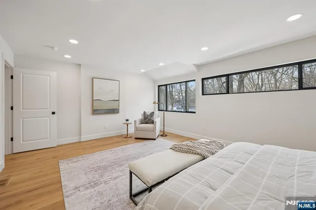 a bedroom with a large bed chandelier and a window