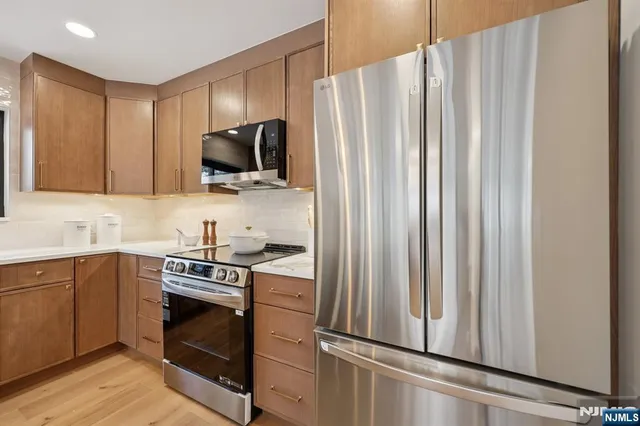 a kitchen with stainless steel appliances a stove microwave and sink