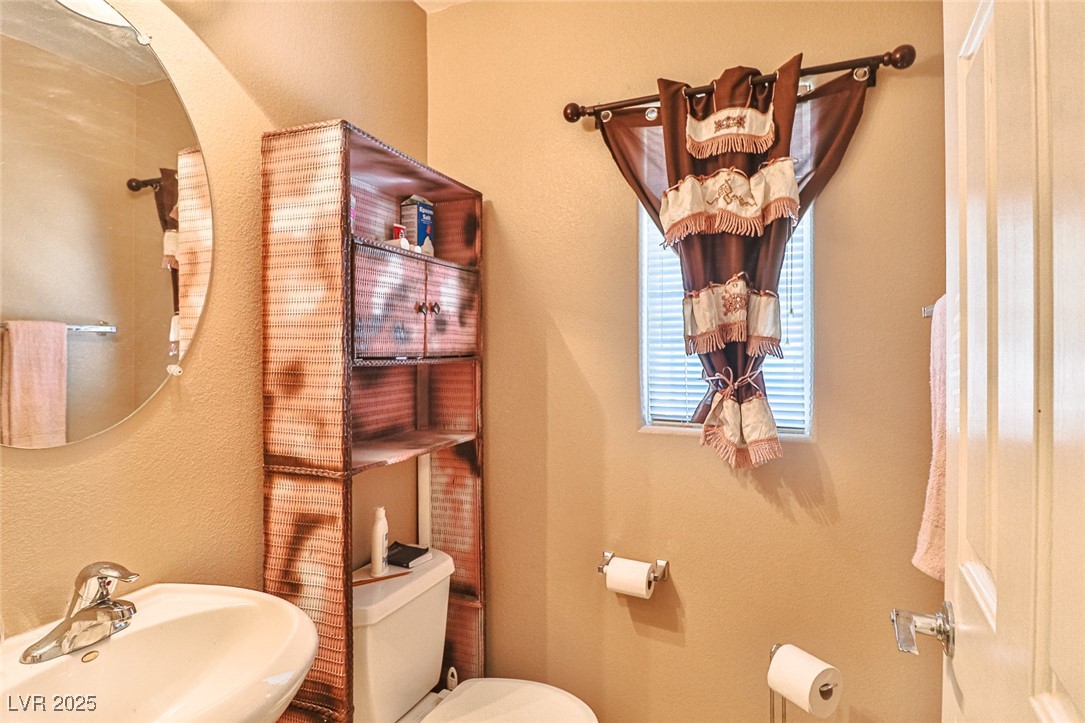 9068 West Alluring Avenue Las Vegas, NV 89149 - Photo 18 of 48 Half bath with a sink and toilet