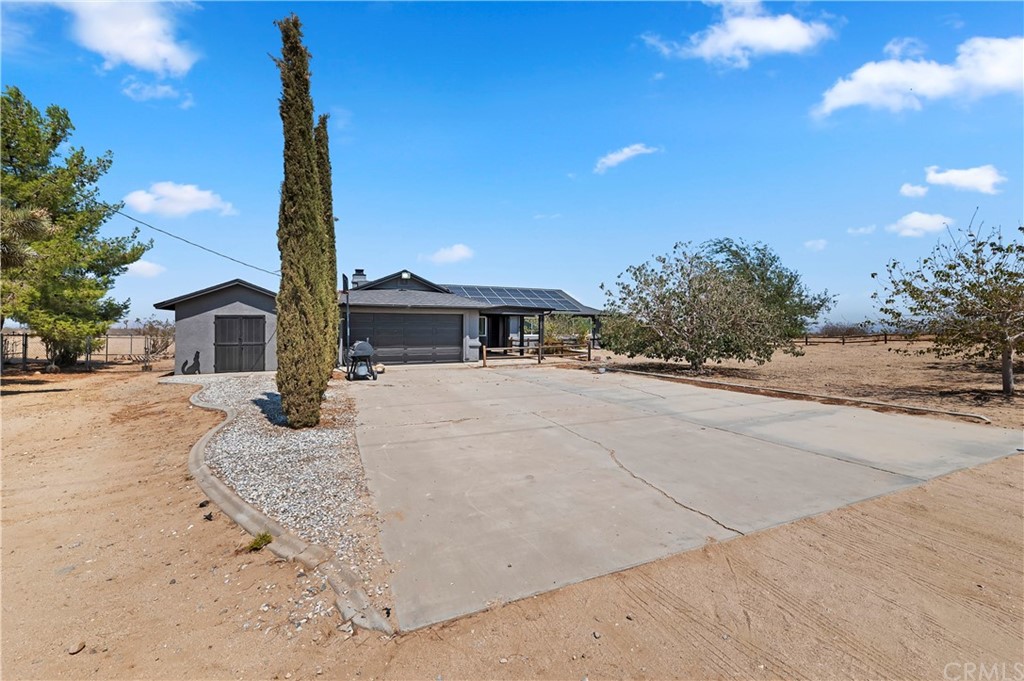 9188 Lindero Road Victorville, CA 92392 - Photo 1 of 1 a front view of a house with a garden and yard