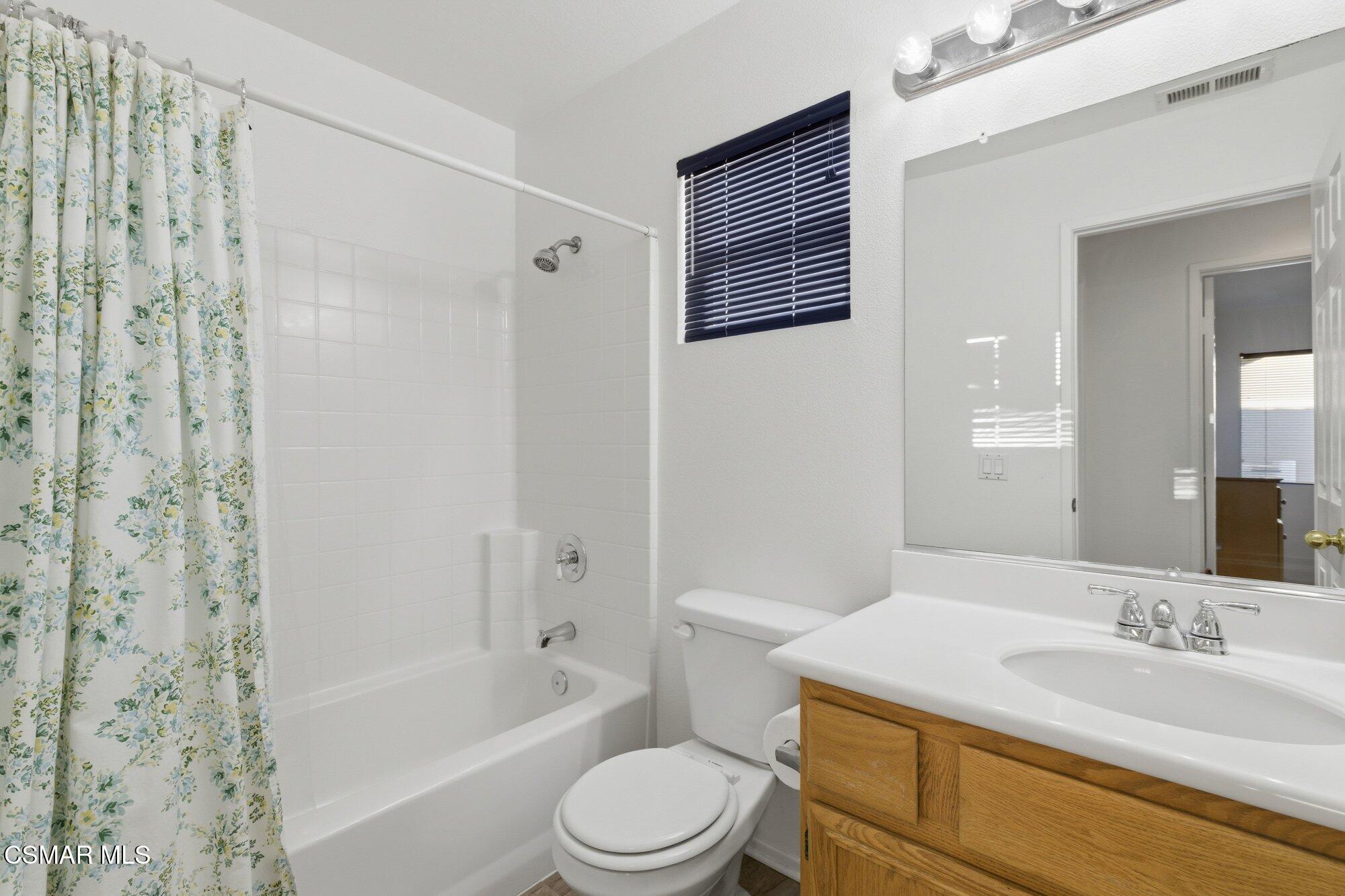 3205 Pine View Drive Simi Valley, CA 93065 - Photo 29 of 72 a bathroom with a granite countertop sink toilet a mirror a bathtub and shower