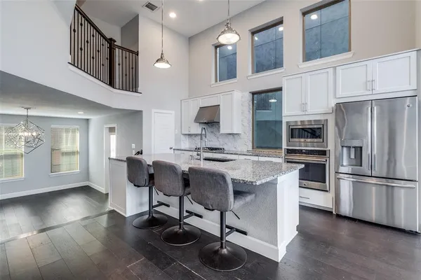 a kitchen with stainless steel appliances granite countertop a stove a sink and a microwave