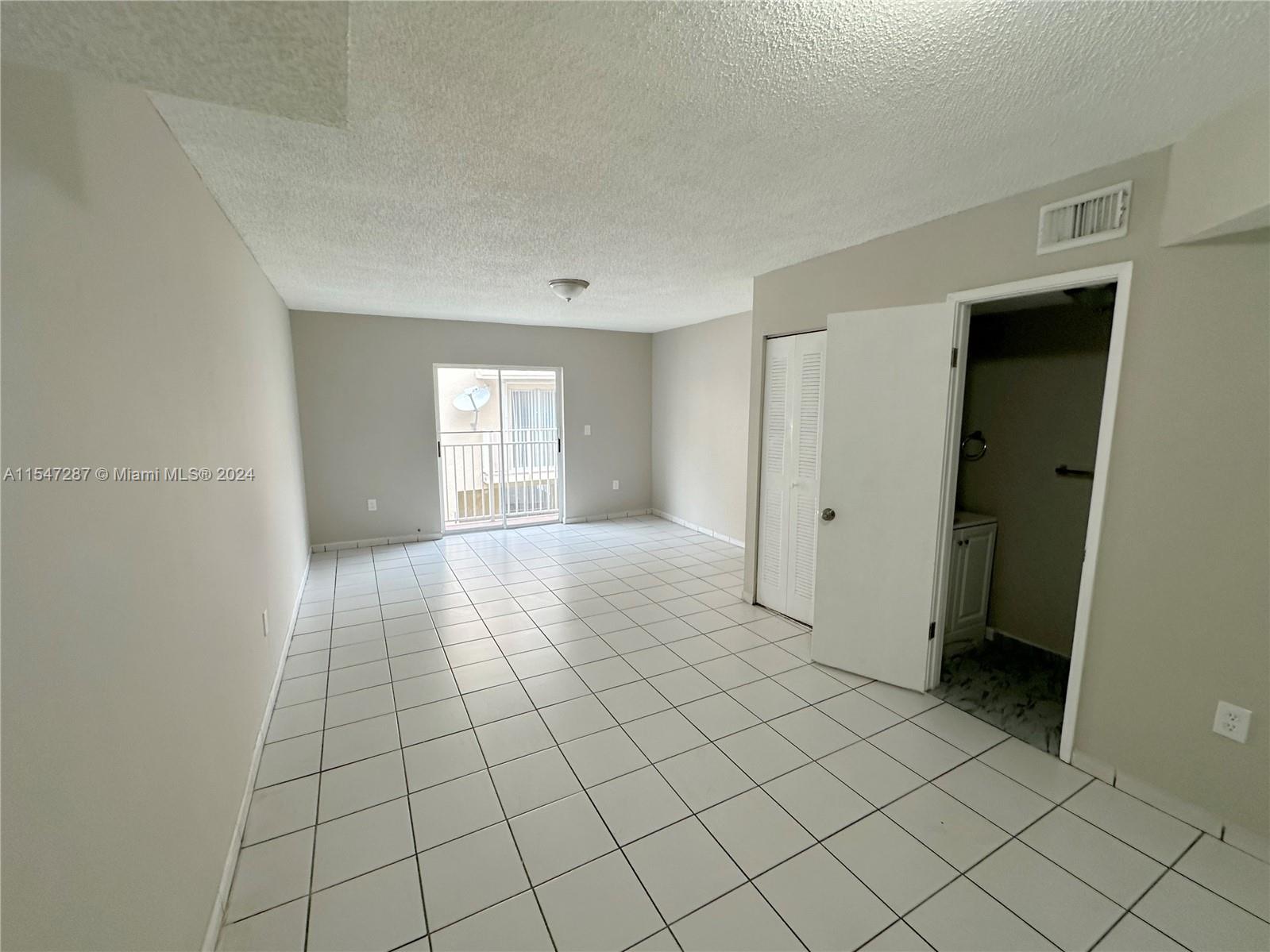 3051 West 76th Street, Unit D211 Hialeah, FL 33018 - Photo 11 of 22 a view of an empty room and window