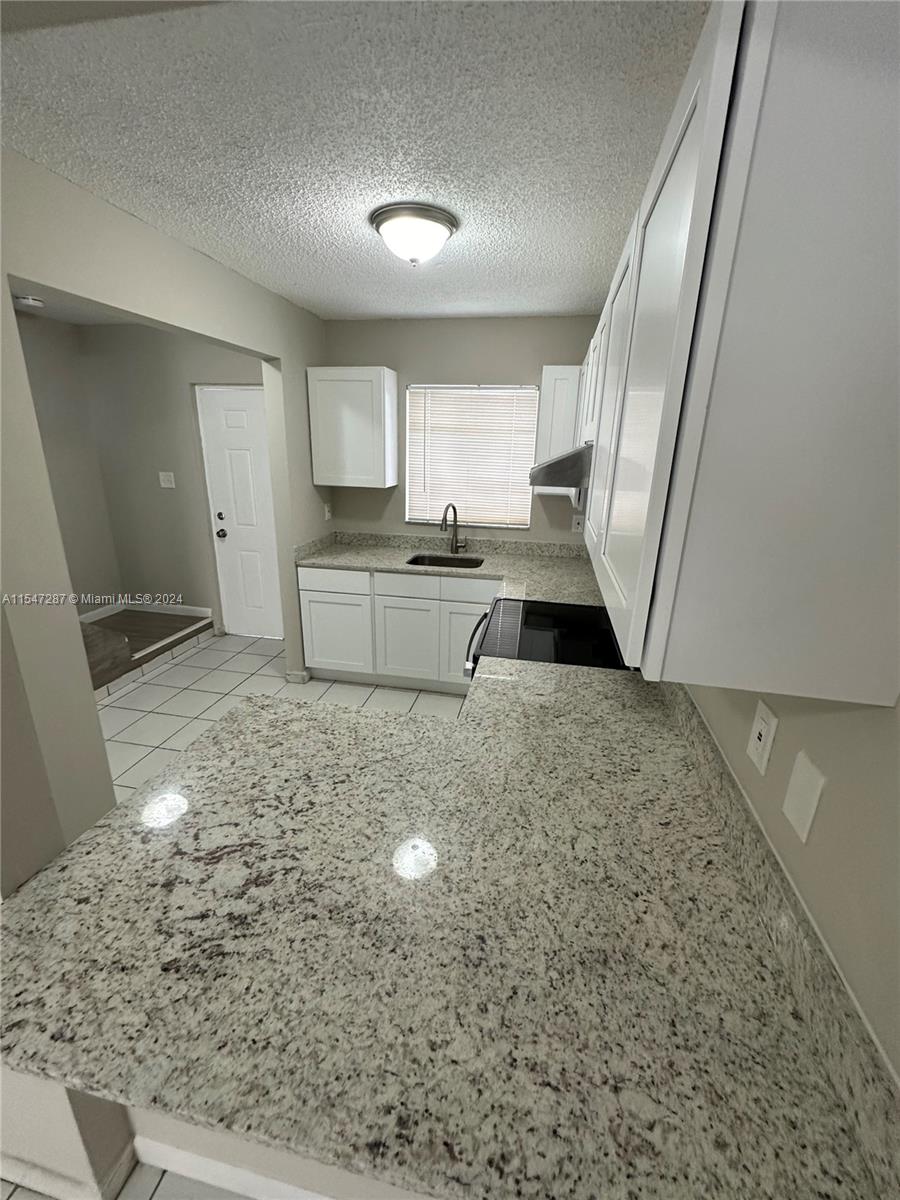 3051 West 76th Street, Unit D211 Hialeah, FL 33018 - Photo 15 of 22 a kitchen with sink and refrigerator