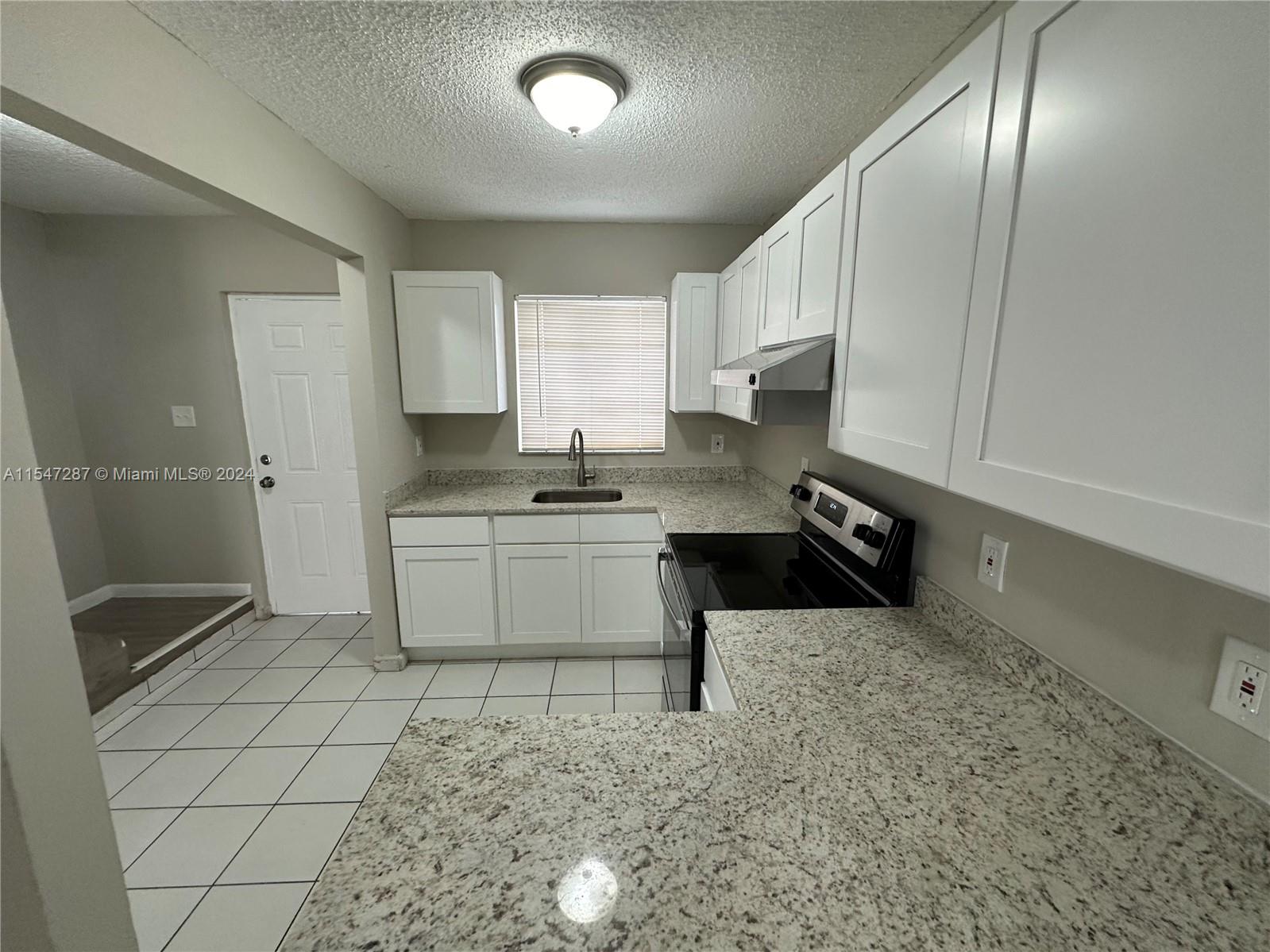3051 West 76th Street, Unit D211 Hialeah, FL 33018 - Photo 16 of 22 a kitchen with stainless steel appliances a sink a stove a refrigerator cabinets and a window