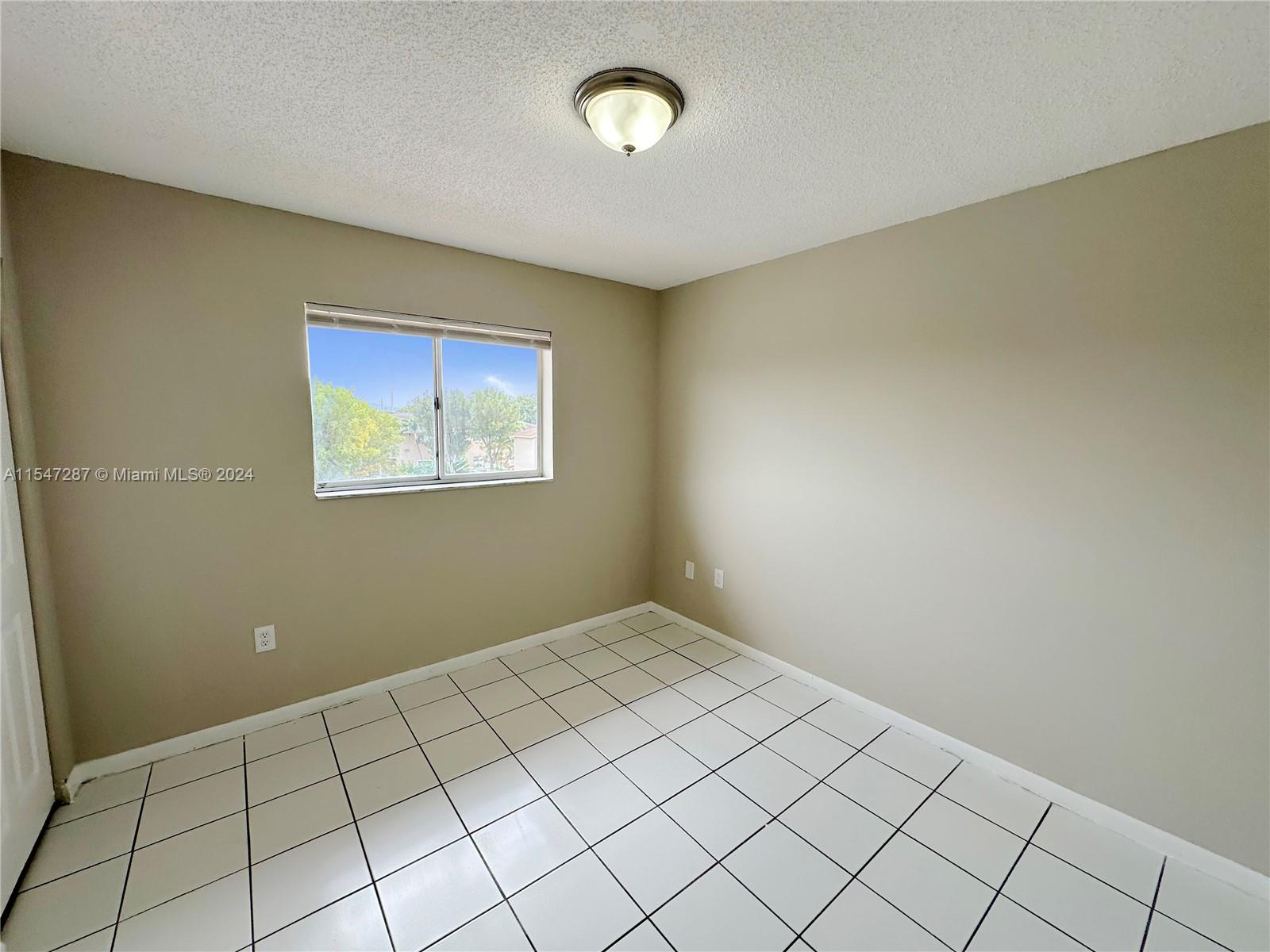 3051 West 76th Street, Unit D211 Hialeah, FL 33018 - Photo 17 of 22 a view of an empty room and window