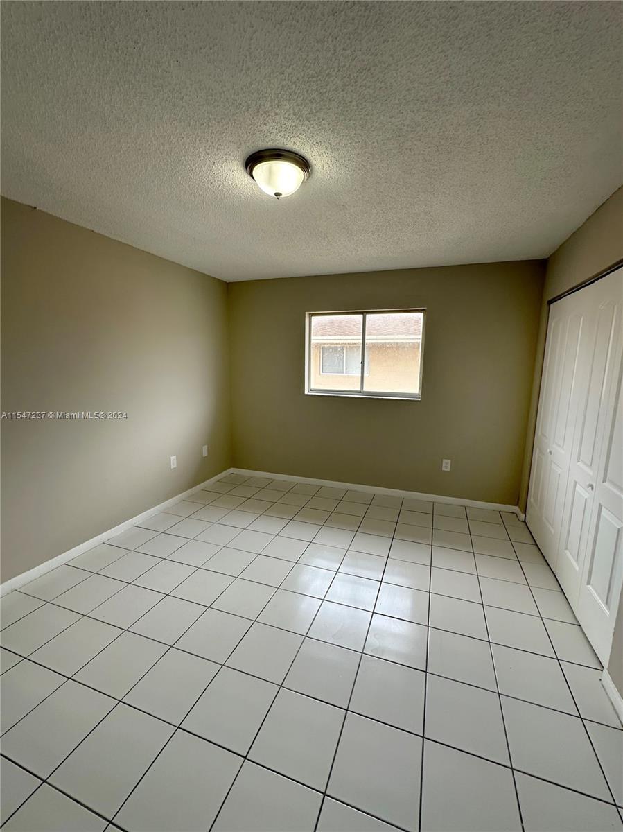 3051 West 76th Street, Unit D211 Hialeah, FL 33018 - Photo 19 of 22 a view of an empty room and window
