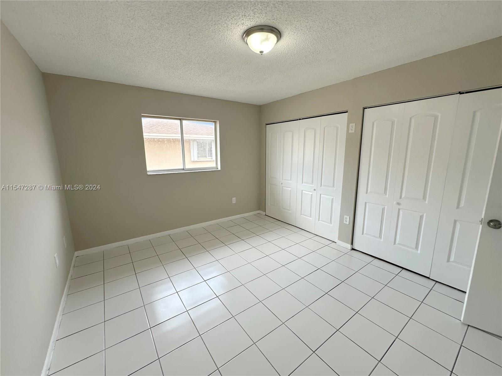 3051 West 76th Street, Unit D211 Hialeah, FL 33018 - Photo 20 of 22 an empty room with windows