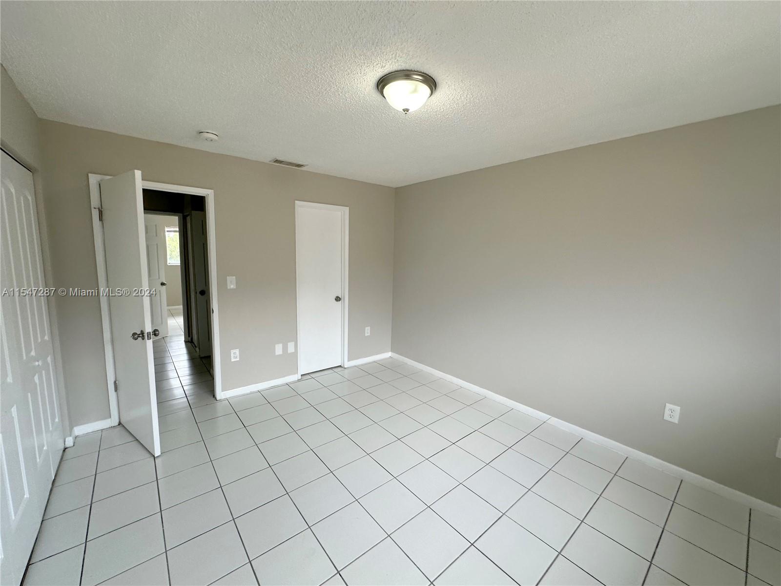 3051 West 76th Street, Unit D211 Hialeah, FL 33018 - Photo 21 of 22 a view of an empty room and window