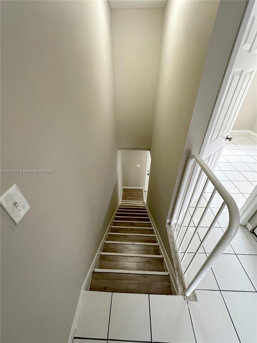 3051 West 76th Street, Unit D211 Hialeah, FL 33018 - Photo 22 of 22 a view of a hallway with stairs