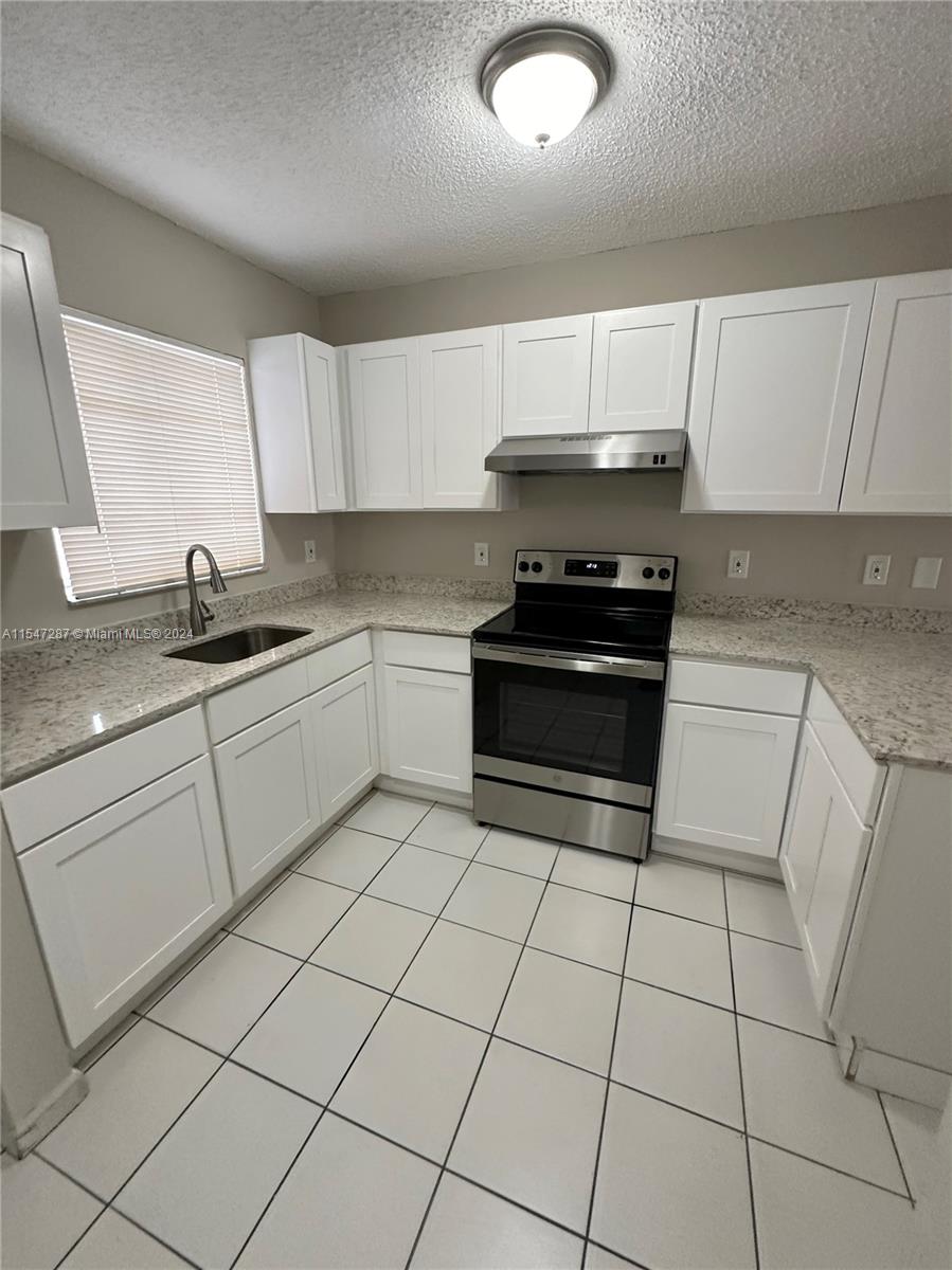 3051 West 76th Street, Unit D211 Hialeah, FL 33018 - Photo 8 of 22 a kitchen with stainless steel appliances granite countertop a sink stove and cabinets