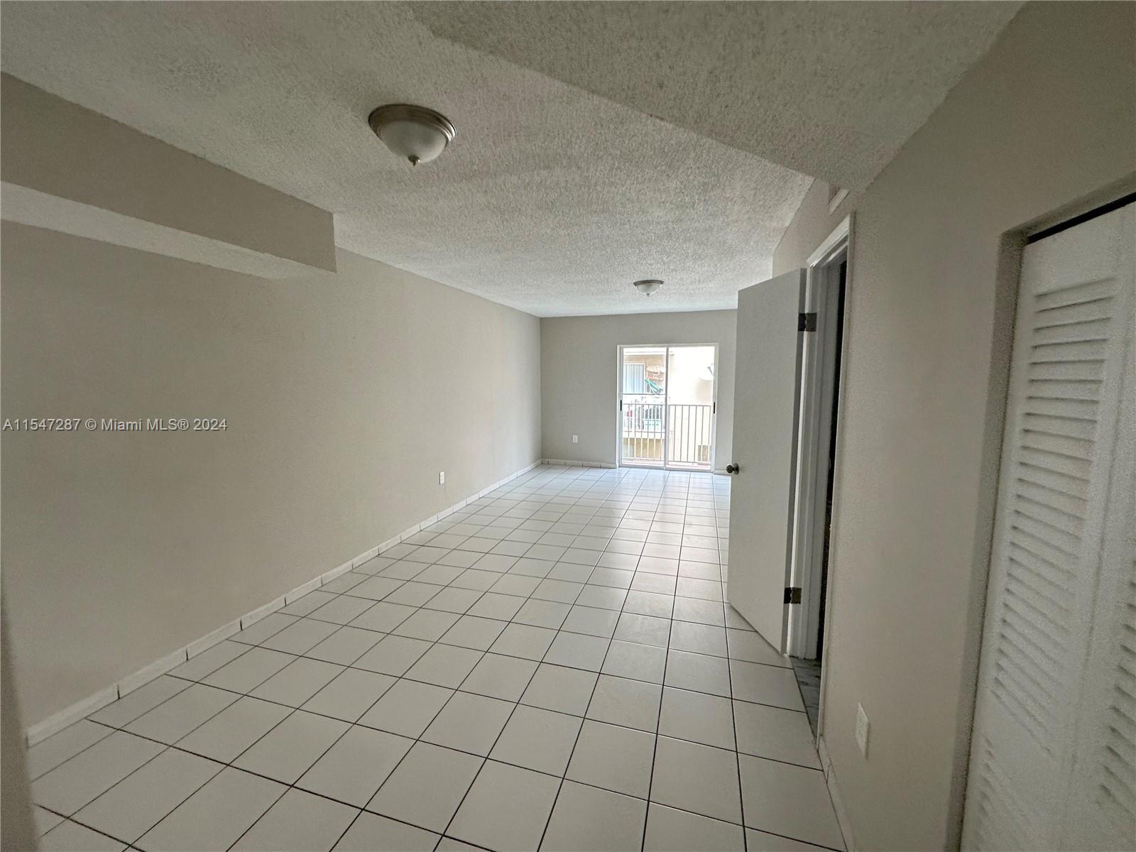 3051 West 76th Street, Unit D211 Hialeah, FL 33018 - Photo 10 of 22 a view of an empty room and window