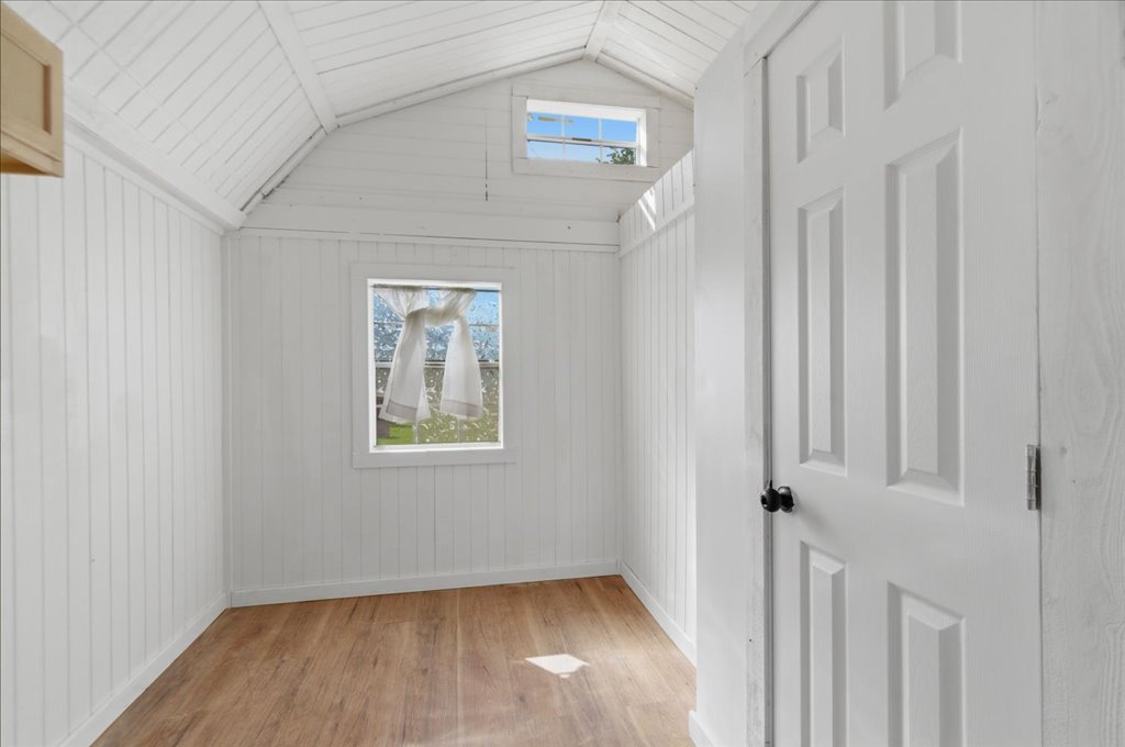 189 Watterson Road Bastrop, TX 78602 - Photo 10 of 22 A well-lit interior space with natural light filtering through two windows and showcasing vaulted ceilings.