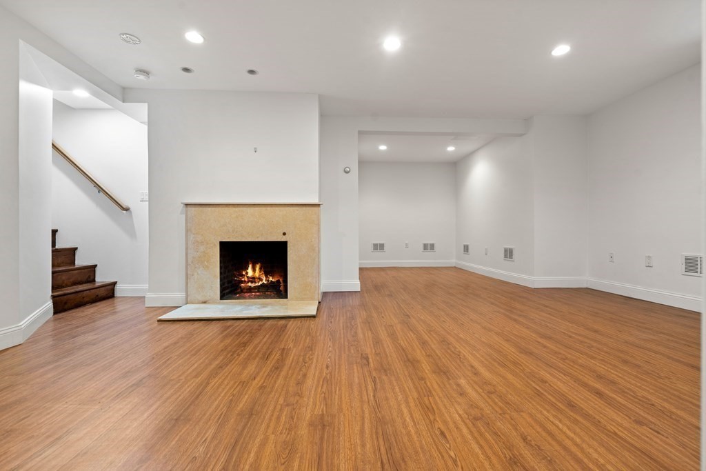 6 Dean Road Marblehead, MA 01945 - Photo 25 of 29 a view of an empty room with wooden floor a fireplace and a window