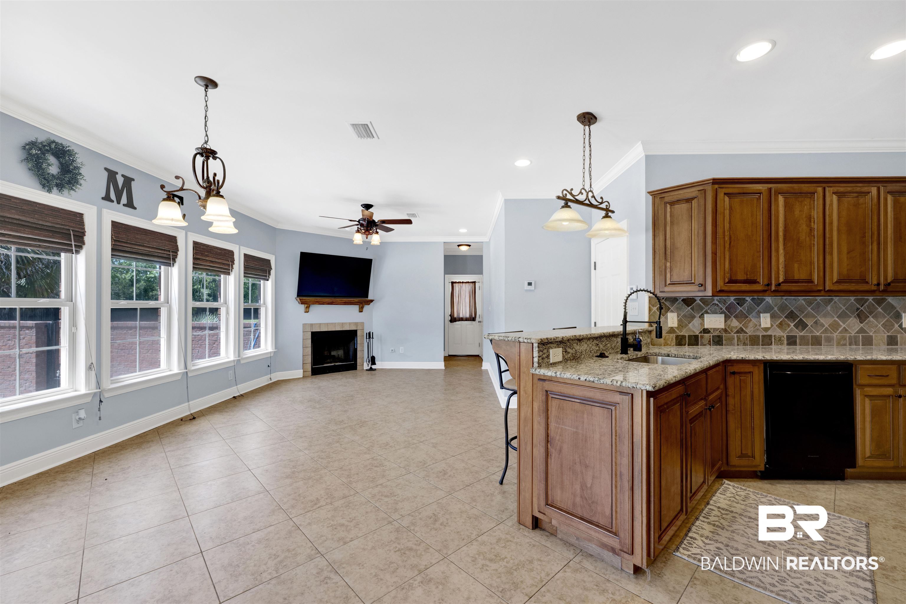 12944 Anna's Way Stapleton, AL 36578 - Photo 37 of 64 Open concept living area featuring a kitchen with wood cabinetry and granite countertops, a tiled backsplash, and recessed lighting