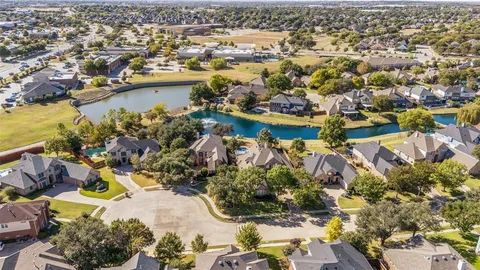 an aerial view of lake and residential houses with outdoor space