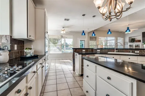a kitchen with stainless steel appliances granite countertop a sink a stove and a wooden cabinets