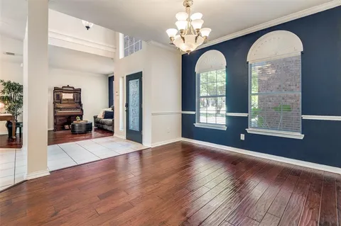 a view of an room with wooden floor chandelier and windows
