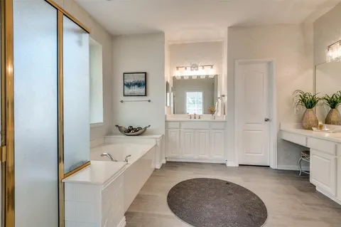 a bathroom with a tub sink and mirror