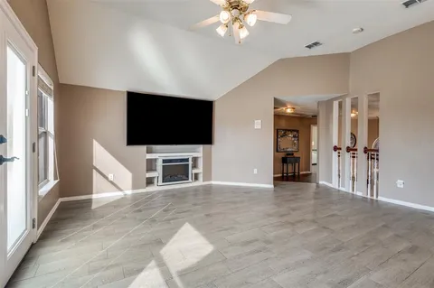 an empty room with furniture and a flat screen tv