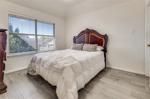 a large bed sitting in a bedroom next to a window