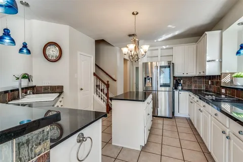 a kitchen with stainless steel appliances granite countertop a sink refrigerator stove and microwave