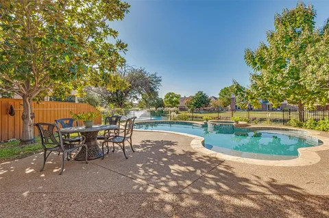 a view of a swimming pool with outdoor seating and plants
