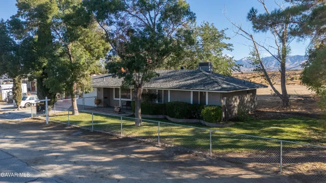 a view of a house with garden and trees