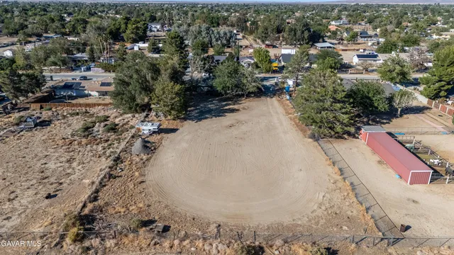 an aerial view of a house with a yard and mountain view in back