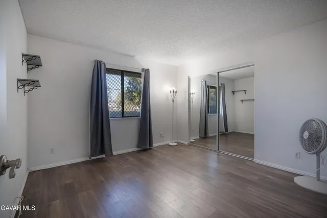 an empty room with wooden floor and mirror