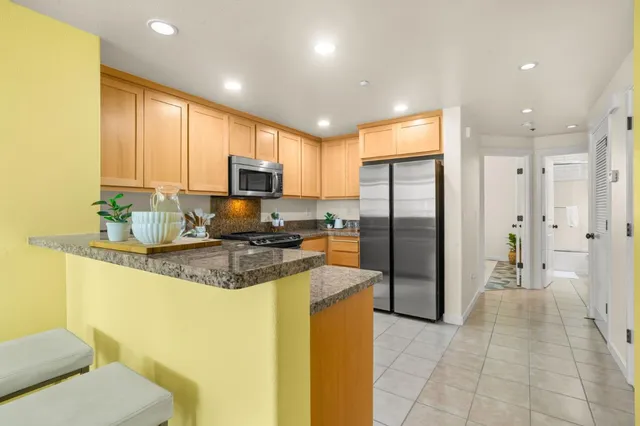 a kitchen with stainless steel appliances granite countertop a stove a sink and a refrigerator