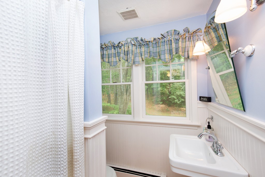 127 Haverhill Road Topsfield, MA 01983 - Photo 22 of 28 a bathroom with a sink a mirror and next to a window