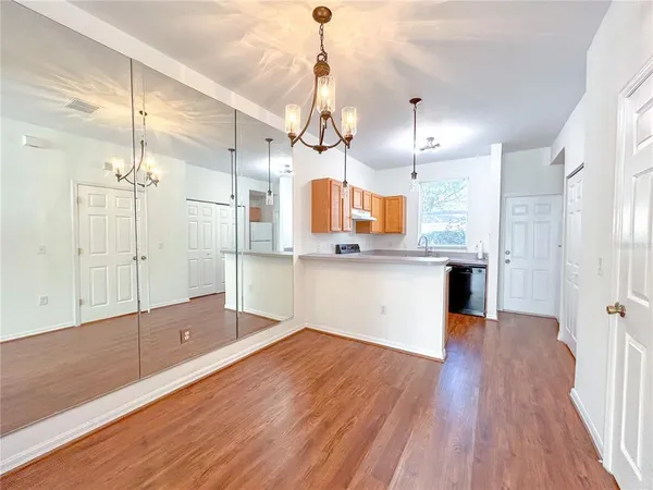 a kitchen with stainless steel appliances kitchen island a hardwood floor and a sink